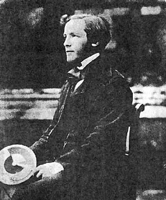 Black and white photo of a young James Clerk Maxwell age 34 holding a color wheel